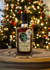 bottle of driftless glen rye in front of christmas tree with pretty lights